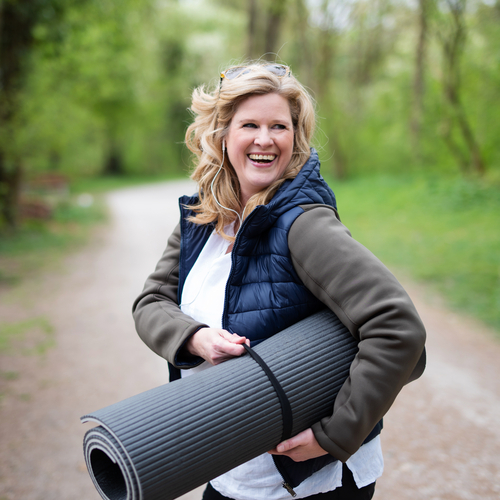 lächende Frau mit Yoga-Matte